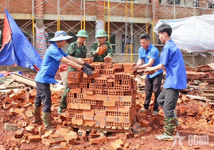 Cán bộ, nhân viên, đoàn viên, thanh niên Đoàn Kinh tế - Quốc phòng 74 hỗ trợ vận chuyển vật liệu.