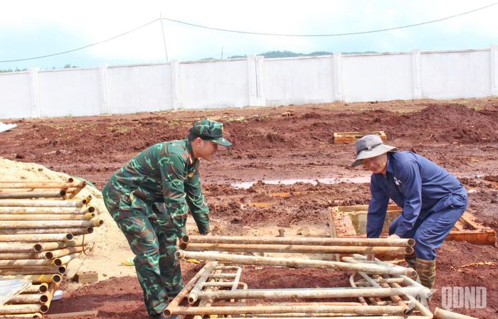 Cán bộ, người lao động Đoàn Kinh tế - Quốc phòng 74 hỗ trợ thu dọn dụng cụ xây dựng.