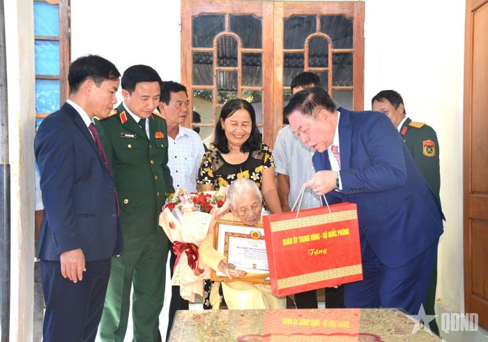 Đại tướng Nguyễn Trọng Nghĩa trao Huy hiệu 80 năm tuổi Đảng và quà của Quân ủy Trung ương, Bộ Quốc phòng tặng đảng viên Trần Thị Trình.  