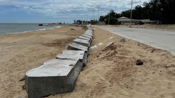 Sau khi đặt bao cát và bê tông chắn sóng, đơn vị thi công tiến hành bơm đất vào móng đường để gia cố chặt hơn.