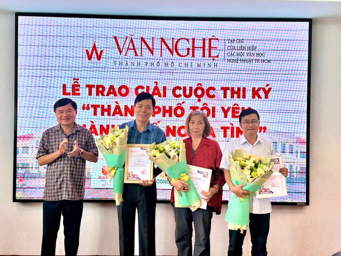 Nhà văn Bùi Anh Tấn, Tổng Biên tập Tạp chí Văn nghệ TPHCM, tặng hoa cảm ơn các thành viên Ban giám khảo. Ảnh: QUỲNH YÊN