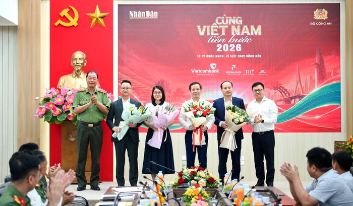 Tổng Biên tập Báo Nhân Dân Lê Quốc Minh tặng hoa các đơn vị đồng hành. Ảnh: BÁO NHÂN DÂN