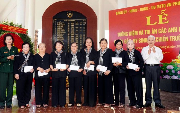 Nguyên Chủ tịch nước Nguyễn Minh Triết trao quà tri ân đến các thương bệnh binh, nữ kháng chiến, cựu chiến binh. Ảnh: VĂN TÂM