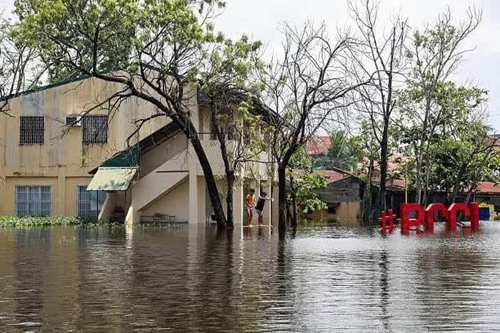 Hai học sinh trở lại lớp học để lấy đồ đạc tại Trường Cao đẳng Trung tâm Pampanga bị ngập do mưa mùa gió mùa ở Apalit, Philippines, ngày 20/8. (Nguồn: Getty Images)