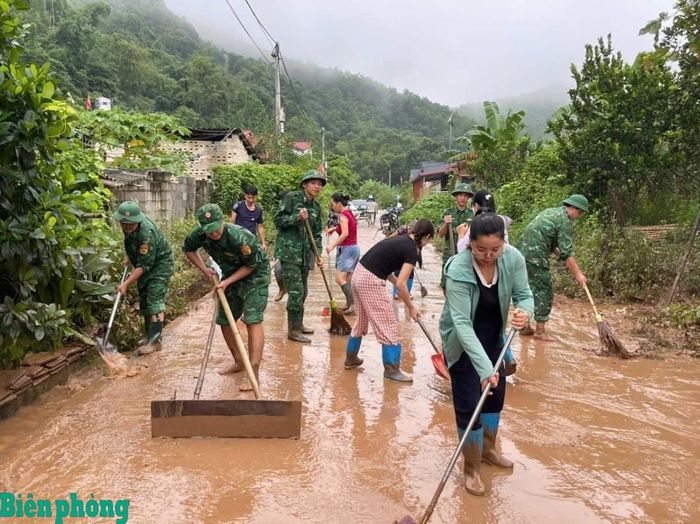 Cán bộ, chiến sĩ Đồn Biên phòng Pò Mã phối hợp với nhân dân vệ sinh đường làng, ngõ xóm sau lũ. Ảnh: Đơn vị cung cấp