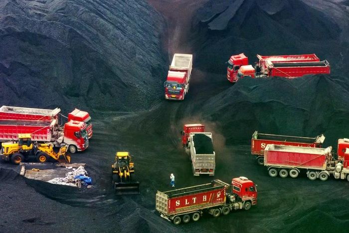 Các xe tải bên cạnh những đống than tại bến container thuộc cảng Quoyuan ở Trùng Khánh, Trung Quốc. Ảnh: Na Bian/Bloomberg.