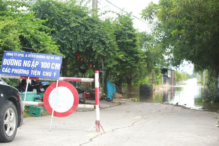 Tại tuyến đường 421B cũ, biển cảnh báo "đường ngập 100cm" cũng được đặt đầu đường. Do nước ngập sâu, người dân không còn di chuyển qua khu vực này.