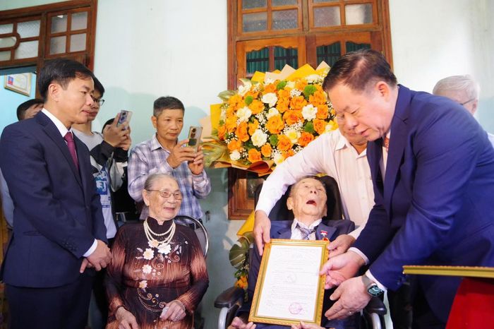 Đại tướng Nguyễn Trọng Nghĩa trao quyết định tặng Huy hiệu Đảng cho đảng viên Nguyễn Anh Hùng. (Ảnh: Xuân Diện)