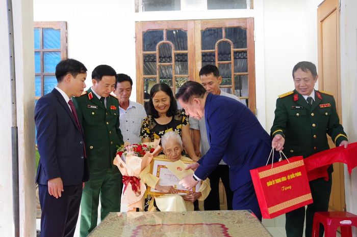  Đại tướng Nguyễn Trọng Nghĩa trao Huy hiệu 80 năm tuổi Đảng cho đảng viên Trần Thị Trình, ở xã Lệ Thủy. (Ảnh: Xuân Diện)