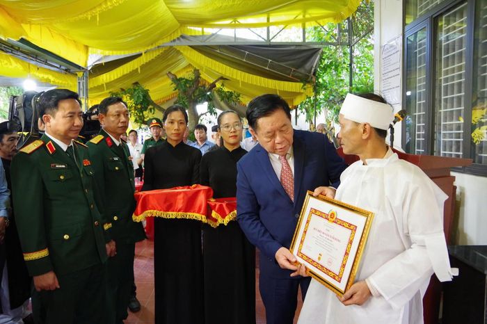 Đại tướng Nguyễn Trọng Nghĩa trao Huy hiệu 80 năm tuổi Đảng cho thân nhân đảng viên Lê Thương, ở xã Vĩnh Định. (Ảnh: Xuân Diện)