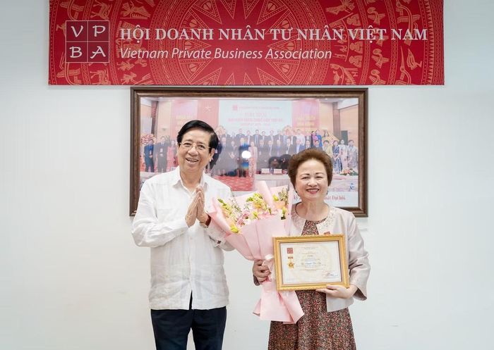 PGS.TS Nguyễn Trọng Điều trao kỷ niệm chương và hoa tặng Bà Nguyễn Thị Nga