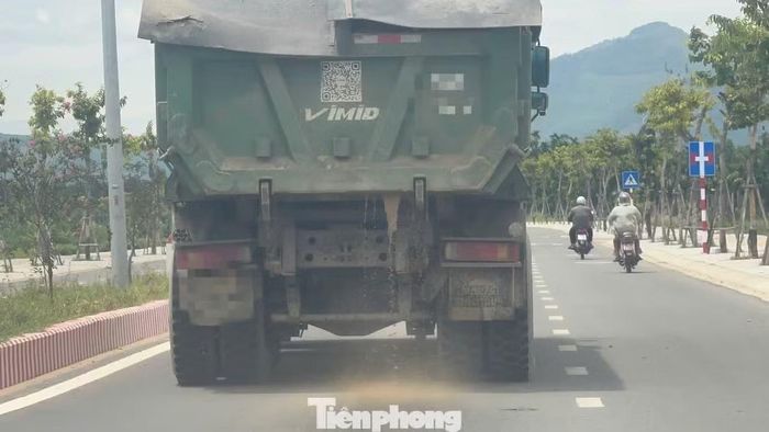 Nước và cát chảy lênh láng trên mặt đường.