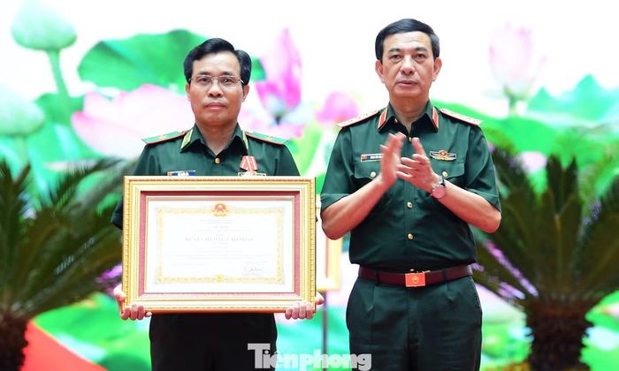 Đại tướng Phan Văn Giang trao Huân chương Lao động hạng Ba của Chủ tịch nước tặng Thiếu tướng Vũ Quốc Ân. Ảnh: Xuân Tùng