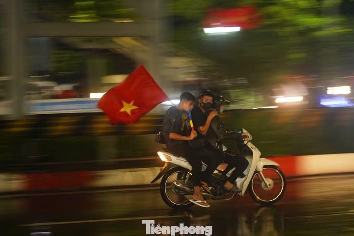 Nhóm thanh niên kẹp 3, không đội mũ bảo hiểm khi đi bão. Ảnh: Duy Phạm