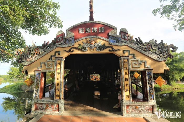Nhìn từ đầu cầu, mái ngói uốn cong cùng hệ khung gỗ và những mảng trang trí sành sứ tạo nên dáng vẻ riêng của công trình. Phía trên nổi bật dòng chữ “Thanh Toàn ngõa kiều”, nghĩa là cầu ngói Thanh Toàn