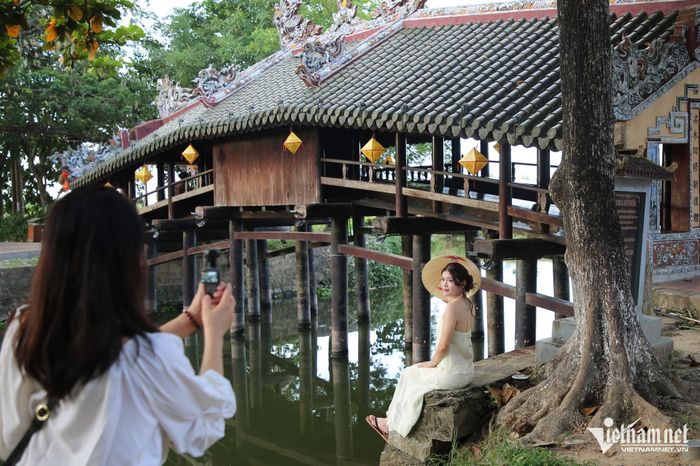 Vẻ xưa cũ cùng cảnh quan xanh mát quanh cầu thu hút nhiều bạn trẻ tìm đến chụp ảnh. Từ bờ kênh, người chụp có thể lấy trọn dáng cầu cùng hình ảnh phản chiếu trên mặt nước