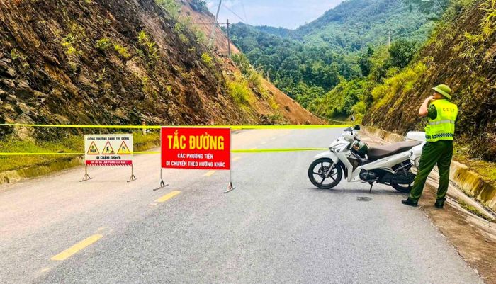 Lực lượng chức năng đã cắm biển cấm lưu thông và tổ chức phân luồng giao thông, không cho các phương tiện tiếp tục đi qua khu vực có nguy cơ sạt lở. Ảnh: Đặng Huế