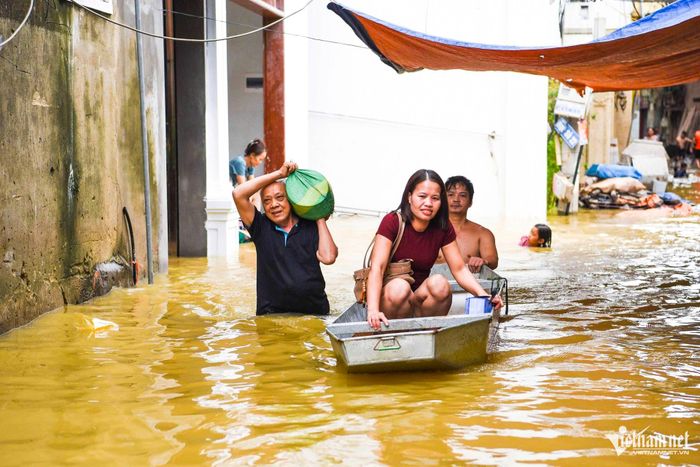 Người dân tổ dân phố Thổ Hà phải dùng thuyền nhỏ để di chuyển trong vùng ngập