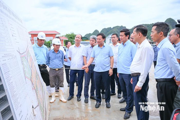 Đoàn công tác Bộ Xây dựng nghe giới thiệu về tiến độ xây dựng Trường phổ thông nội trú liên cấp Tiểu học và THCS Anh Sơn. Ảnh: Thành Cường
