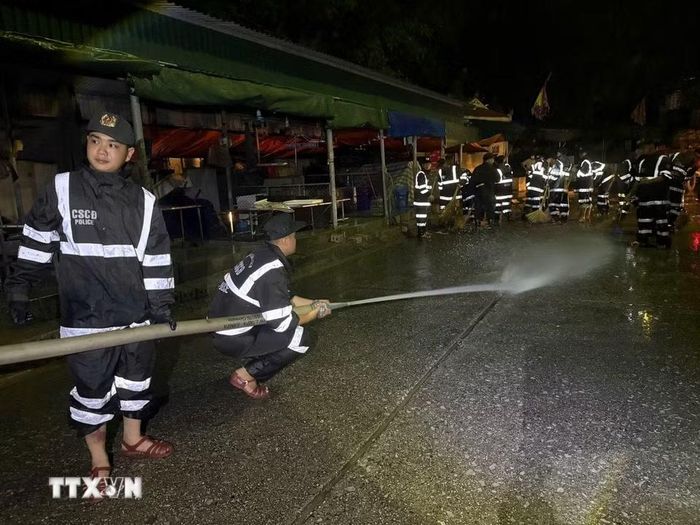 Cán bộ, chiến sỹ tổ chức phun nước vệ sinh trong chợ. (Ảnh: Tiến Vĩnh/TTXVN)