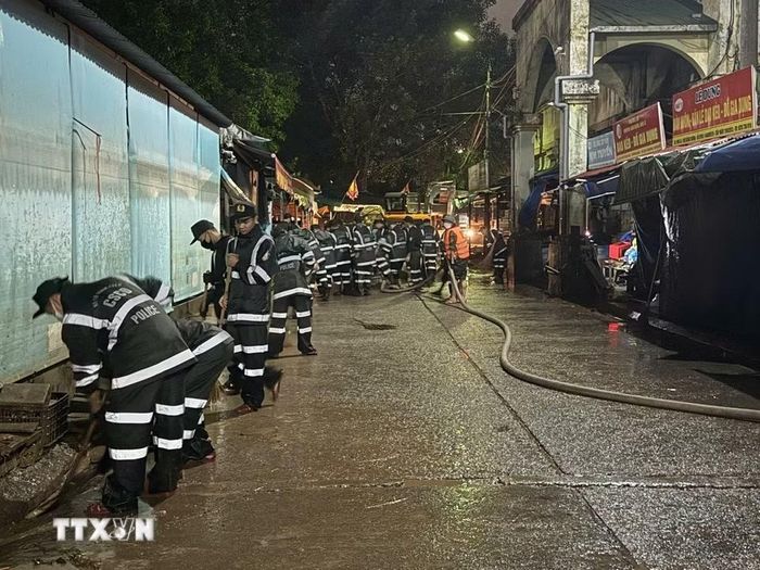 Lực lượng chức năng tổ chức dọn dẹp các lối đi trong chợ. (Ảnh: Tiến Vĩnh/TTXVN)