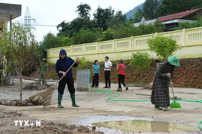 Các phụ huynh hỗ trợ giáo viên để cùng dọn dẹp, vệ sinh khuôn viên trường lớp, sẵn sàng đón trẻ đến trường. (Ảnh: Việt Dũng/TTXVN)