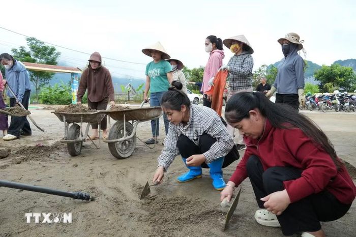 Các phụ huynh hỗ trợ giáo viên để cùng dọn dẹp, vệ sinh khuôn viên trường lớp, sẵn sàng đón trẻ đến trường. (Ảnh: Việt Dũng/TTXVN)