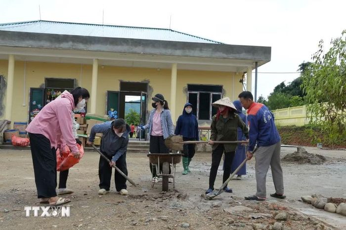 Giáo viên, phụ huynh và công nhân nhà thầu thi công chung tay, khẩn trương dọn dẹp khuôn viên điểm trường Bản Chít của Trường Mầm non Mường Than (Lai Châu). (Ảnh: Việt Dũng/TTXVN)