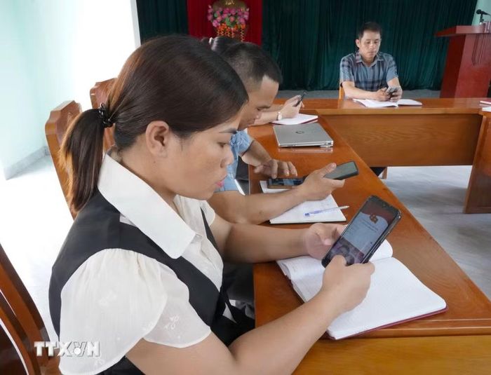 Đảng viên tra cứu tài liệu trên điện thoại thông minh. (Ảnh: Thanh Thủy/TTXVN)
