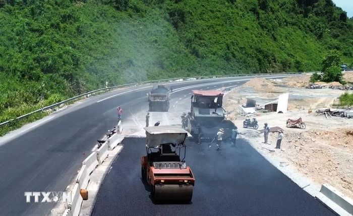 Nhà thầu gấp rút thi công thảm nhựa sẵn sàng thông tuyến chính vào 31/8 tới. (Ảnh: Quốc Khánh/TTXVN)