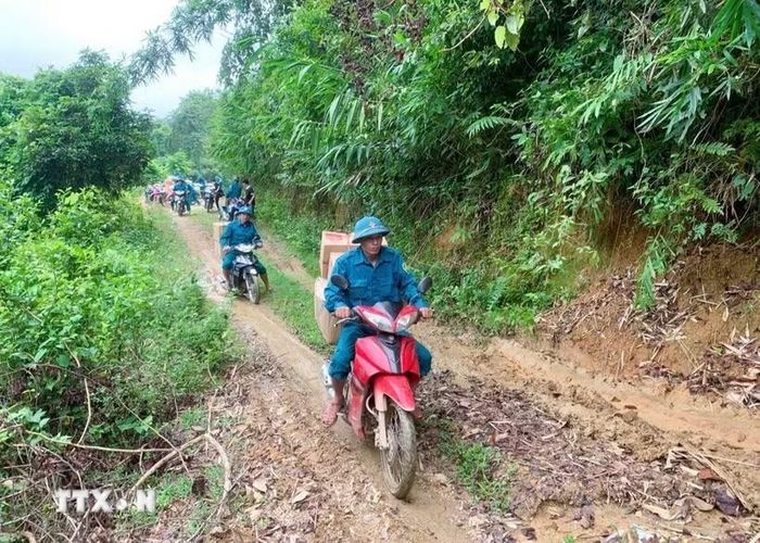 Hành trình chở lương thực, thực phẩm, nhu yếu phẩm bằng xe máy xuyên đại ngàn Pù Huống vào hỗ trợ cho bà con dân bản Na Ngân. (Ảnh: TTXVN phát)