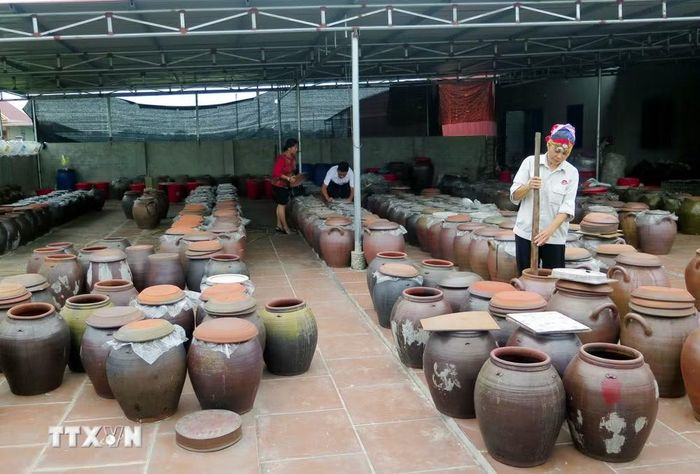 Trong ảnh: Người dân sử dụng chum sành để ngả tương và sử dụng gậy tre sạch để khuấy đều 2-3 lần/ngày. (Ảnh: Quân Trang/TTXVN)