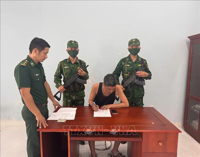 Trung tá Nguyễn Minh Trí, Phó Đồn trưởng Nghiệp vụ, Đồn Biên phòng Phước Chỉ hướng dẫn ông Onomura Hiromitsu (quốc tịch Nhật Bản) viết lời khai. Ảnh: TTXVN phát