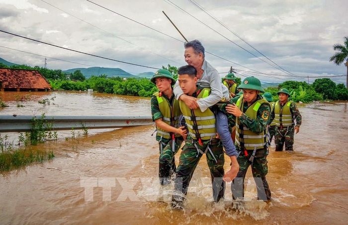 Cán bộ chiến sĩ Sư đoàn 325 hỗ trợ người dân trên địa bàn xã Nam Dương di dời. Ảnh: Danh Lam - TTXVN