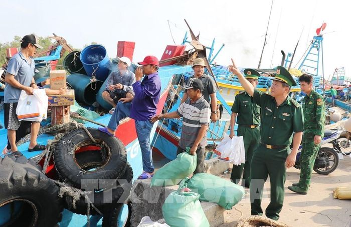 Bộ đội Biên phòng tỉnh Đồng Tháp tuyên truyền về phòng, chống khai thác IUU cho ngư dân xã Gia Thuận trước khi ra khơi Ảnh: Hữu Chí - TTXVN