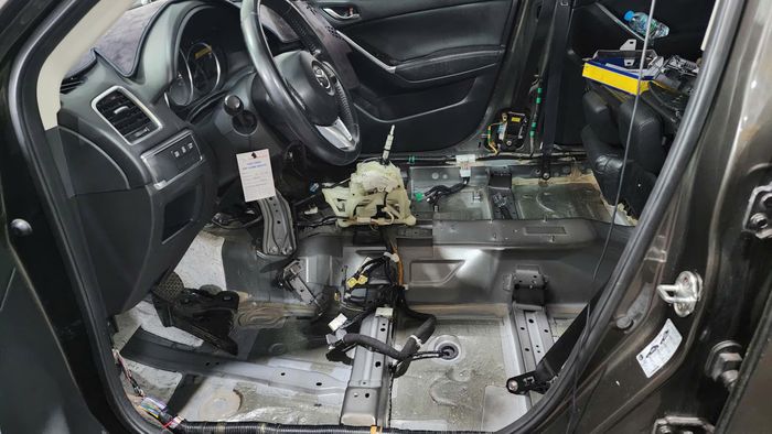 Một chiếc xe ô tô bị tràn nước vào trong xe qua ống thoát nước cửa sổ trời, thợ xe tháo toàn bộ ghế, nỉ sản ra sấy khô, kiểm tra, xử lý các giắc cắm điện (Ảnh: Đỗ Quang).