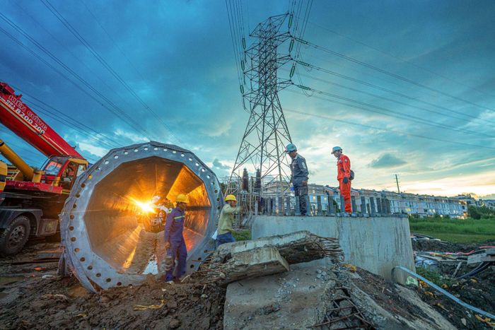 Công nhân lắp dựng trụ thép đơn thân tại công trường ngầm hóa lưới điện 220kV tuyến Nhà Bè – Tao Đàn, đoạn từ trạm Nhà Bè đến cầu Rạch Đỉa.