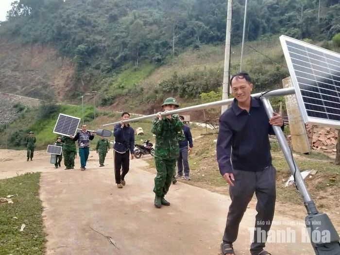 Cán bộ, chiến sĩ Đồn Biên phòng Tam Chung cùng người dân lắp đặt đèn năng lượng mặt trời tại bản Ón.