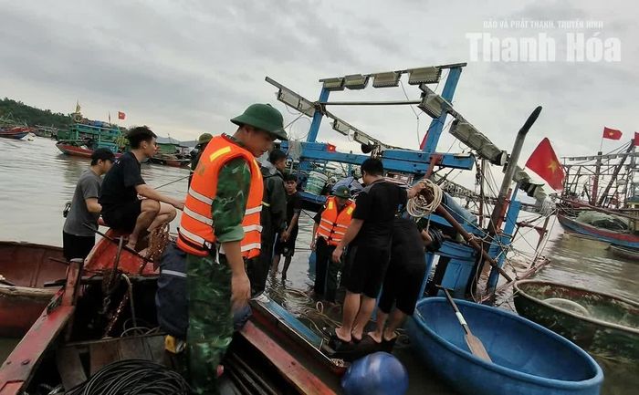 Các lực lượng chức năng và người dân tổ dân phố Nam Sơn phối hợp trực vớt tàu bị chìm.