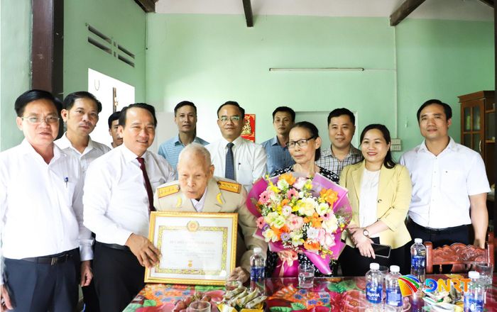 Phó Bí thư Thành ủy, Chủ tịch Ủy ban MTTQ Việt Nam thành phố Nguyễn Đình Vĩnh (thứ 3, bên trái sang) trao Huy hiệu 80 năm tuổi Đảng cho đảng viên Phan Song. Ảnh: NGỌC PHÚ