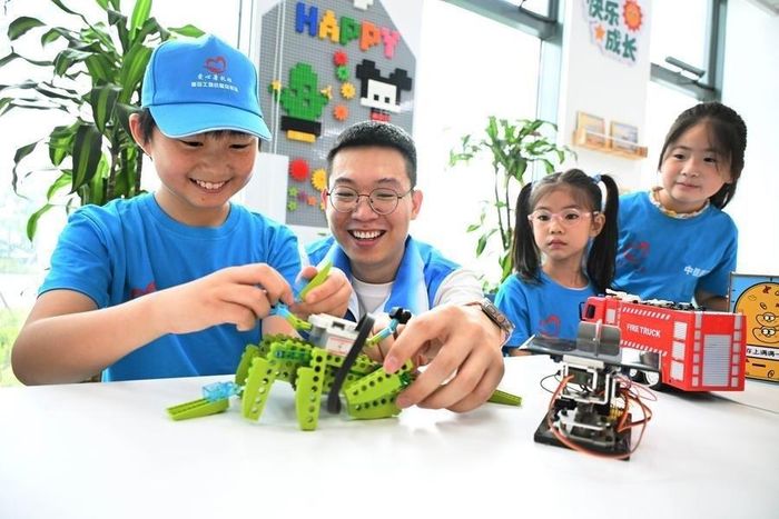 Một tình nguyện viên (thứ 2 từ trái sang) hướng dẫn học sinh lắp ráp robot ở Thanh Đảo (tỉnh Sơn Đông, phía đông Trung Quốc). Ảnh: Tân Hoa xã