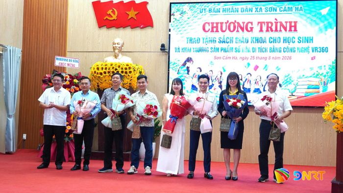Lãnh đạo UBND xã Sơn Cẩm Hà tặng hoa tri ân đóng góp của các tổ chức, doanh nghiệp, cá nhân. Ảnh: D.LỆ