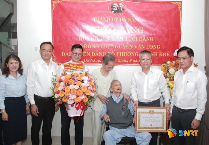 Chủ tịch HĐND thành phố Nguyễn Đức Dũng trao Huy hiệu 80 năm tuổi Đảng cho đảng viên Nguyễn Vạn Long. Ảnh: ĐẮC MẠNH