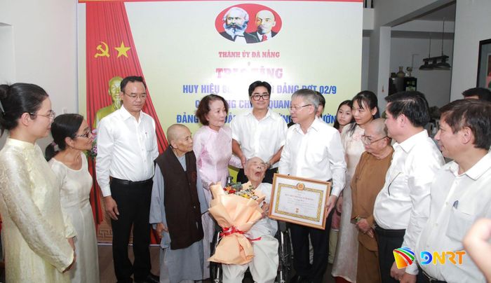 Chủ tịch HĐND thành phố Nguyễn Đức Dũng trao Huy hiệu 80 năm tuổi Đảng cho đảng viên Vũ Quang Thành. Ảnh: ĐẮC MẠNH