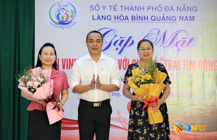 Giám đốc Làng Hòa Bình Quảng Nam Nguyễn Thành Trung (giữa) tặng hoa tri ân nguyên lãnh đạo Sở Lao động - Thương binh và Xã hội Quảng Nam cũ. Ảnh: ALĂNG NGƯỚC