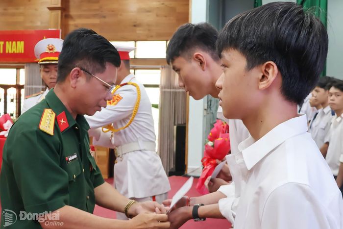 Đại tá Nguyễn Thanh Phong, Thành ủy viên, Phó Bí thư Thường trực Đảng ủy, Chính ủy Bộ Chỉ huy Quân sự thành phố tặng quà tuyên dương học viên trúng tuyển. Ảnh: Nguyệt Hà