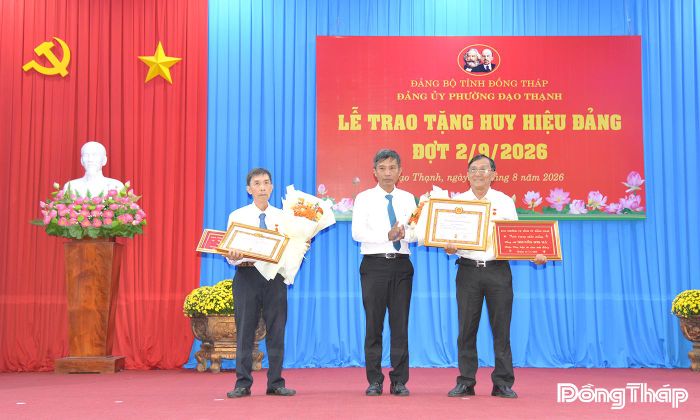 Đồng chí Trịnh Văn Lợi, Bí thư Đảng ủy, Chủ tịch HĐND phường Đạo Thạnh, trao Huy hiệu 50 năm tuổi Đảng, khánh vàng và tặng hoa cho đồng chí Nguyễn Sơn Hà, đảng viên Chi bộ Khu phố 11 và đồng chí Lê Tấn Sơn, đảng viên Chi bộ Khu phố 12, phường Đạo Thạnh.