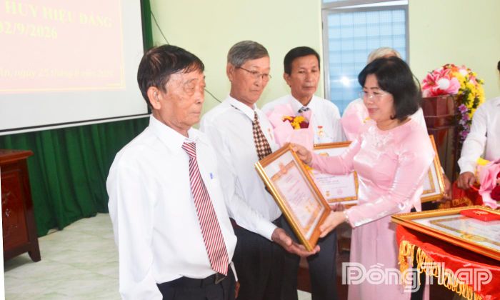 Đồng chí Phạm Thị Mai Tiên (bìa phải) trao Huy hiệu Đảng cho đảng viên xã Mỹ Tịnh An.
