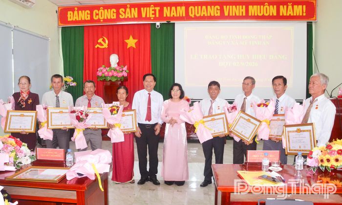 Đồng chí Phạm Thị Mai Tiên (đứng thứ 6 từ trái qua) cùng lãnh đạo xã Mỹ Tịnh An trao Huy hiệu Đảng cho các đảng viên trên địa bàn xã.