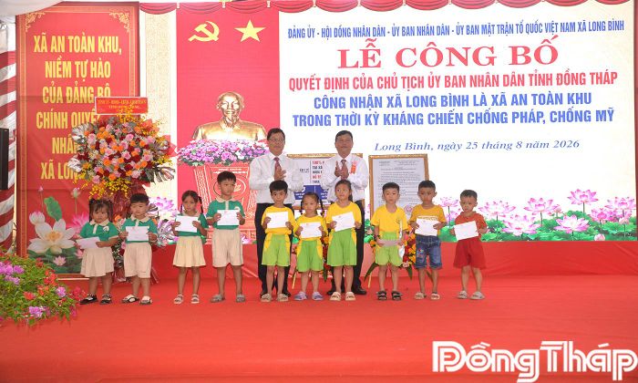 Đồng chí Trần Thanh Nguyên và đồng chí Võ Ngọc Tân trao học bổng cho các em học sinh.